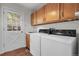 A laundry room featuring a washer and dryer, sink, wood cabinets, and an exterior door at 150 Soda Creek Rd, Evergreen, CO 80439