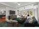 Modern living room with plush seating, fireplace, TV, and large windows overlooking the trees at 150 Soda Creek Rd, Evergreen, CO 80439