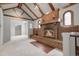 Spacious living room with a brick fireplace, wooden beam ceiling, arched windows, and carpeted floors at 150 Soda Creek Rd, Evergreen, CO 80439