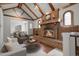 Bright and airy living room featuring a brick fireplace, with wooden beam ceiling and a glimpse of the dining room at 150 Soda Creek Rd, Evergreen, CO 80439