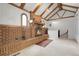 Cozy living room with a large brick fireplace, wooden beam ceiling, arched windows, and carpeted floors at 150 Soda Creek Rd, Evergreen, CO 80439