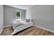 Neutral bedroom with a window, hardwood floors, a queen-sized bed, and soothing grey paint at 19155 E Kansas Dr, Aurora, CO 80017