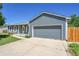 Charming single-story home featuring a two-car garage, and a well-maintained front yard under a clear blue sky at 19155 E Kansas Dr, Aurora, CO 80017