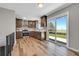 Well-lit kitchen featuring wood floors, wooden cabinets, stainless steel appliances, and a sliding glass door leading to the outside at 19155 E Kansas Dr, Aurora, CO 80017