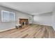 Bright living room featuring a brick fireplace, two windows, hardwood floor, and modern furniture at 19155 E Kansas Dr, Aurora, CO 80017