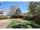 Spacious backyard with lawn and mature trees provides a private outdoor space at 9652 Cove Creek Dr, Highlands Ranch, CO 80129