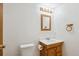 Bathroom featuring a single-sink vanity, toilet, framed mirror and updated lighting at 9652 Cove Creek Dr, Highlands Ranch, CO 80129