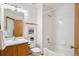 Full bathroom with a tub-shower, framed art, and vanity with warm wood tones and white porcelain sink at 9652 Cove Creek Dr, Highlands Ranch, CO 80129