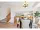Dining area featuring a modern chandelier, four chairs, view of the living room and stairs at 9652 Cove Creek Dr, Highlands Ranch, CO 80129