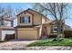 Two-story home with tan siding, brick accents, and a well-maintained lawn at 9652 Cove Creek Dr, Highlands Ranch, CO 80129