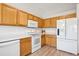 Bright kitchen with white appliances and wooden cabinets at 9652 Cove Creek Dr, Highlands Ranch, CO 80129