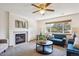 Cozy living room with a fireplace, ceiling fan, and large window at 9652 Cove Creek Dr, Highlands Ranch, CO 80129