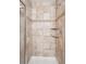 Elegant walk-in shower featuring tan tile, built-in shelves, and modern fixtures at 9652 Cove Creek Dr, Highlands Ranch, CO 80129
