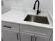 Modern laundry sink with matte black faucet, white counter top, and sleek hardware on cabinets at 2545 S Leyden St, Denver, CO 80222