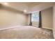 Finished basement has neutral paint, plush carpet, and a window for natural light at 940 Kearney St, Denver, CO 80220