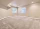 This spacious basement has neutral paint, plush carpet, and natural light from two windows at 940 Kearney St, Denver, CO 80220