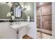 Charming bathroom with pedestal sink, unique lighting, and tiled shower; perfect for guest or powder room at 940 Kearney St, Denver, CO 80220
