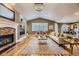 Cozy living room features a stone fireplace, built-in shelves, hardwood floors and large windows with natural light at 940 Kearney St, Denver, CO 80220