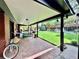 Covered brick patio features a dining table, seating, and a lovely view of the expansive lawn at 2774 S Milwaukee St, Denver, CO 80210