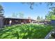 Large backyard with a covered patio, wood deck with seating and dining table, and a spacious lawn at 2774 S Milwaukee St, Denver, CO 80210