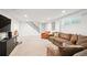 Spacious finished basement with a large sectional sofa, neutral carpet, and modern staircase at 2774 S Milwaukee St, Denver, CO 80210