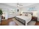 Bedroom with wood floors, a ceiling fan, two windows, and a bed with end tables at 2774 S Milwaukee St, Denver, CO 80210