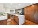 Spacious kitchen features modern stainless appliances, hardwood floors, an island, and wood cabinets at 2774 S Milwaukee St, Denver, CO 80210
