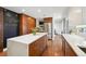 Open kitchen features a large island, stainless steel refrigerator, and dark wood cabinets at 2774 S Milwaukee St, Denver, CO 80210