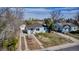 Aerial view of a charming house with a driveway, front yard, mature trees, and adjacent house at 1108 Roslyn St, Denver, CO 80220