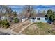 Aerial view of a charming house with a driveway, front yard, mature trees, and adjacent house at 1108 Roslyn St, Denver, CO 80220