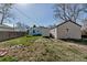 Large backyard with green grass, mature trees, fencing, shed, and detached garage at 1108 Roslyn St, Denver, CO 80220