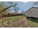 Large backyard with green grass, mature trees, fencing, shed, and detached garage at 1108 Roslyn St, Denver, CO 80220