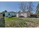 Large backyard with green grass, mature trees, fencing, shed, and detached garage at 1108 Roslyn St, Denver, CO 80220