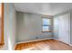 Bedroom with hardwood floors, neutral walls, a window, and a white door at 1108 Roslyn St, Denver, CO 80220