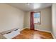 Bedroom featuring hardwood floors, a window, red curtains, neutral walls and bench seat at 1108 Roslyn St, Denver, CO 80220