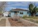 Quaint home with light blue siding and a detached garage showcases its classic charm and functional outdoor space at 1108 Roslyn St, Denver, CO 80220