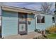 Close-up of the front door of a charming light blue home, with a decorative security door and visible house number at 1108 Roslyn St, Denver, CO 80220
