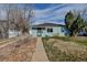 Charming single-story home featuring mature trees and a well-maintained lawn, enhancing curb appeal at 1108 Roslyn St, Denver, CO 80220