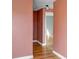 View of hallway with salmon-colored walls, white trim and hardwood flooring at 1108 Roslyn St, Denver, CO 80220