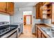Traditional kitchen featuring wood cabinets, stainless appliances, wood countertop, and view to front entry at 1108 Roslyn St, Denver, CO 80220