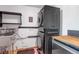 Bright laundry room with stainless steel sink, floating shelves, and stacked, front-loading, dark-colored washer/dryer at 1108 Roslyn St, Denver, CO 80220