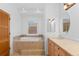 Bathroom featuring a tub with tile surround and a large window at 1172 S Steele St, Denver, CO 80210