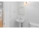Classic white bathroom features a pedestal sink, wainscoting, and ample natural light at 1172 S Steele St, Denver, CO 80210