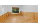 Bedroom with paneling, hardwood floors, and a large window offering a view of trees at 1172 S Steele St, Denver, CO 80210