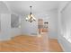 Elegant dining room features hardwood floors, white walls, and an ornate chandelier; kitchen in background at 1172 S Steele St, Denver, CO 80210