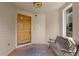 Charming front porch with a wood door, tile floor, bench, and a decorative ceiling light fixture at 1172 S Steele St, Denver, CO 80210
