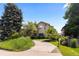 Beautiful home featuring a well-manicured lawn, mature trees, and a curved driveway for added charm at 1172 S Steele St, Denver, CO 80210