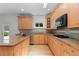 Well-lit kitchen with custom wood cabinets, stainless steel appliances, and granite countertops at 1172 S Steele St, Denver, CO 80210