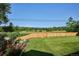 A spacious backyard showcasing a lush green lawn and beautifully landscaped garden beds and shrubs at 2300 Crabtree Dr, Centennial, CO 80121