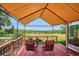 Covered deck featuring comfortable seating and views of the beautifully maintained backyard and horizon at 2300 Crabtree Dr, Centennial, CO 80121